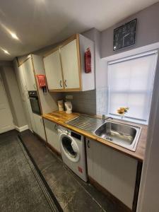 una pequeña cocina con fregadero y lavadora en 2 Kilkerran Road, en Campbeltown
