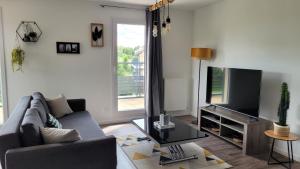 a living room with a couch and a flat screen tv at LOVELY By Dream Apartments in Montévrain