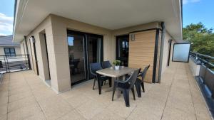a patio with a table and chairs on a balcony at LOVELY By Dream Apartments in Montévrain