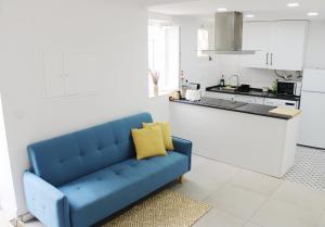 un sofá azul en una habitación con cocina en Casa das Nobres, en Évora
