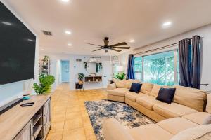 a living room with a large couch and a flat screen tv at Miami Gardens Getaway in Miami Gardens