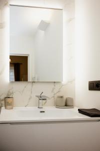 a white bathroom with a sink and a mirror at Beauty Suite in Brussels