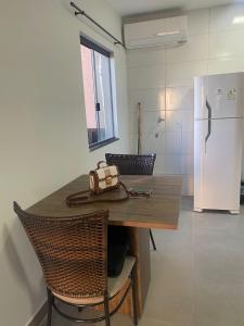 a kitchen with a wooden table and a white refrigerator at Apto 2 qts, wifi, netflix, metrô próximo in Brasília