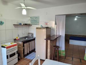 a small kitchen with a refrigerator and a sink at Kitchenette Charmosa no Itagua in Ubatuba