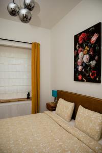 1 dormitorio con 1 cama y una pintura en la pared en Beauty Suite, en Bruselas