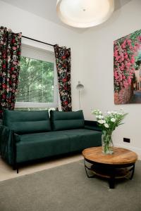 a green couch in a living room with a table at Beauty Suite in Brussels