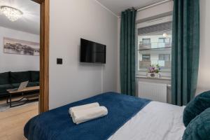 a bedroom with a blue bed and a mirror at Apartament Sowa Deluxe in Bielsko-Biala