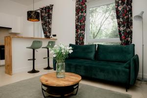 a living room with a green couch and a table at Beauty Suite in Brussels
