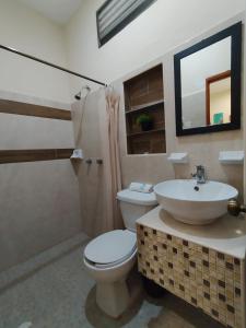 a bathroom with a toilet and a sink at Hotel San Miguel in Progreso