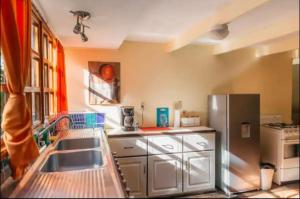 a kitchen with a sink and a refrigerator at Hotel La Colina in Manuel Antonio