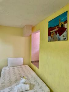 Habitación con cama y pintura en la pared en Hotel Bigu, en Puerto Escondido