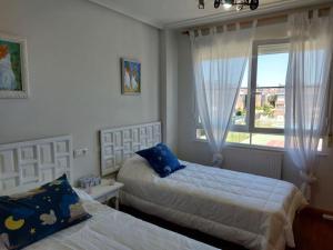 1 Schlafzimmer mit 2 Betten und einem Fenster in der Unterkunft Chalet urbano en Salamanca in Santa Marta de Tormes