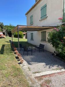 un patio con sillas y una mesa frente a una casa en La Guitoune, en Mane