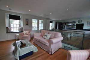 a living room with two couches and a kitchen at The Old Stables- charming cottage Crail in Crail