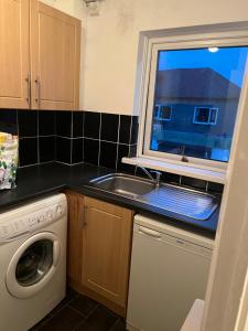 a kitchen with a sink and a washing machine at Goodwin Apartments in Carlisle