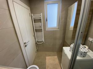 La salle de bains est pourvue d'une douche, de toilettes et d'une fenêtre. dans l'établissement Apartment Riverside, à Novi Beograd