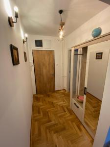 - un couloir doté de parquet et d'une porte dans l'établissement Apartment Riverside, à Novi Beograd