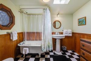 a bathroom with a bath tub and a sink at Taylor Made Cottage in Bodega Bay +19 photos