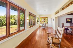 a dining room with windows and a table and chairs at The Aloha Villa - 30-Night Minimum in Honokaa