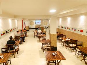 a restaurant with wooden tables and people sitting at tables at Hotel do Largo Manaus in Manaus