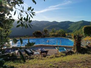 uma piscina com montanhas ao fundo em Country House Il Biroccio em Urbino