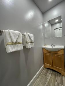 a bathroom with a sink and a mirror and towels at Howard Johnson by Wyndham Ridgecrest, CA in Ridgecrest