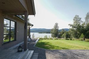 un porche de una casa con vistas al lago en Luxury Norwegian Cottage, en Hurdal