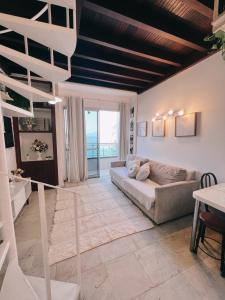 ein Wohnzimmer mit einer Couch und einer Treppe in der Unterkunft angra dos reis, angra inn, vista mar duplex in Angra dos Reis