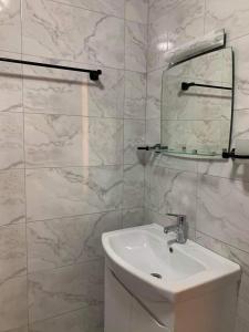 bagno bianco con lavandino e specchio di bismillah hotel and restaurent a Gudauri