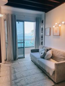 ein Wohnzimmer mit Couch und großem Fenster in der Unterkunft angra dos reis, angra inn, vista mar duplex in Angra dos Reis