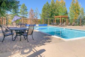 a patio with a table and chairs next to a pool at Rockies Condo 2407 in Steamboat Springs