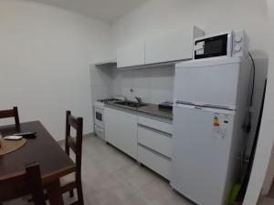 uma cozinha com um frigorífico branco e uma mesa em TresA -1- em Tres Arroyos