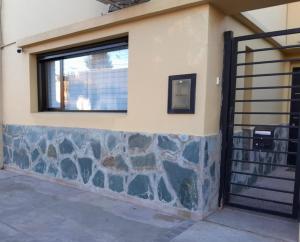 a building with a window and a stone wall at TresA -1- in Tres Arroyos