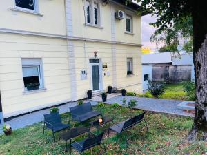 a group of chairs and a table in front of a house at Lemonwood House in Postojna