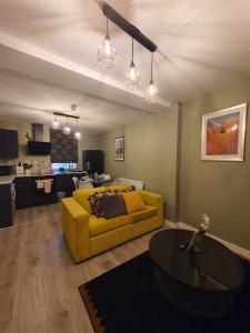 a living room with a yellow couch and a table at Stylish Ashford Gem - Sleeps 6 in Kent