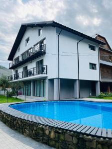 a building with a swimming pool in front of a building at Gostynets in Yaremche