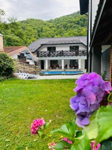 una casa con un patio con flores púrpuras en Gostynets, en Yaremche