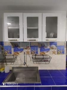 Il comprend une cuisine avec un évier et 3 fenêtres. dans l'établissement Lujoso, frente a la playa, con terraza y vista al mar ., à Santa Marta
