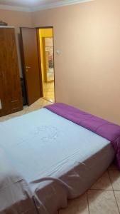 a large bed in a room with purple sheets at Casy&Angy in Braşov