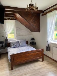 a bedroom with a bed and two windows at Hotel Tys in Dilove