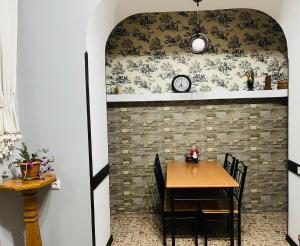 a dining room with a table and a clock on a wall at Jeji's apartment in Tbilisi City