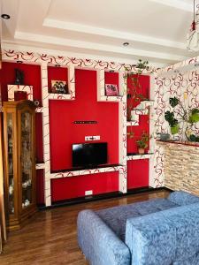 a living room with red walls and a couch at Jeji's apartment in Tbilisi City