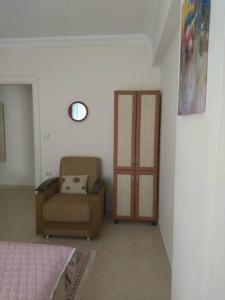 a living room with a chair and a door at Светлая квартира с отдельной кухней и ванной 1+1 in Didim