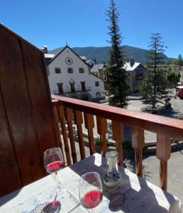a table with two glasses of wine on a balcony at PLAZA centro in Biescas