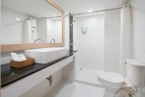 ein weißes Bad mit einem Waschbecken und einem WC in der Unterkunft G Boutique Silom Hotel in Bangkok