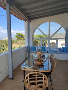 Un patio con una mesa y sillas y un sofá. en Summer family house 300m from the beach, en Kastraki Naxou