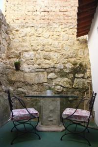 una mesa y 2 sillas frente a una pared de piedra en Casa de la Libelula, en Astudillo