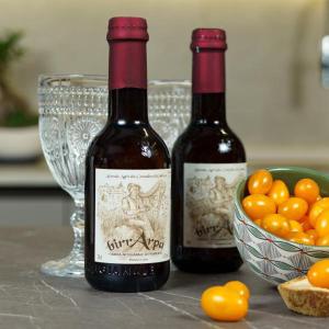 dos botellas de vino sentadas junto a un tazón de naranjas en Rinaldo Holiday Home, en Sambuca di Sicilia