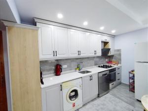 a kitchen with white cabinets and a washing machine at Manolyam suit 5 .1+1 in Kaş