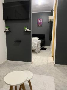 a room with a white stool and a bedroom at Loft moderno próximo Aeroporto e UPF in Passo Fundo